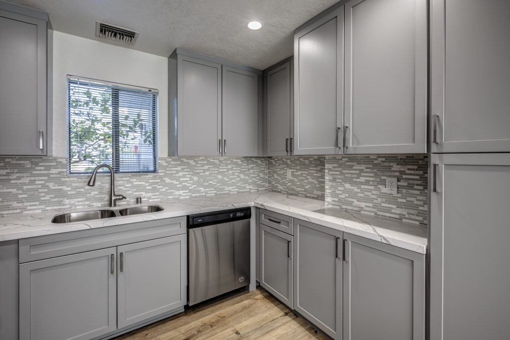 Apartments in Sherman Oaks featuring a sleek kitchen with gray cabinets and stainless steel appliances.